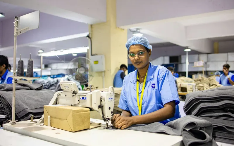 A textile worker sewing at a garment factory production line