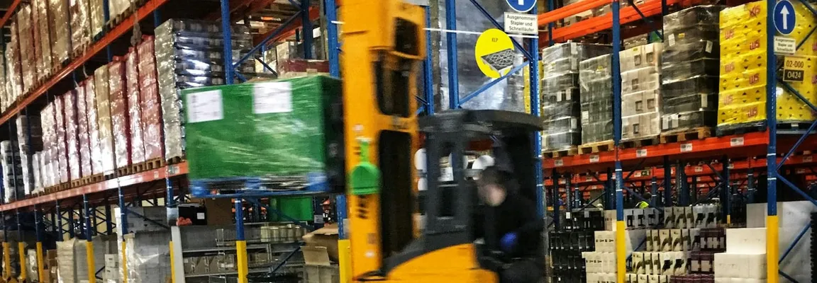 A forklift moving pallets through a warehouse